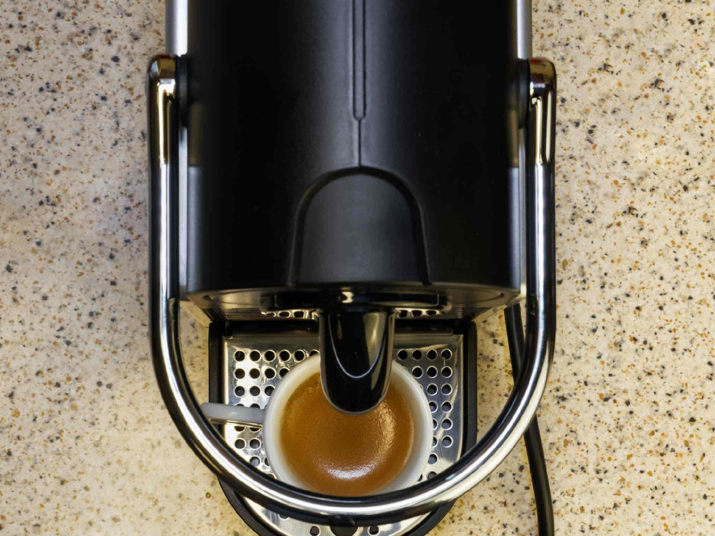 A black coffee machine and a full mug of coffee