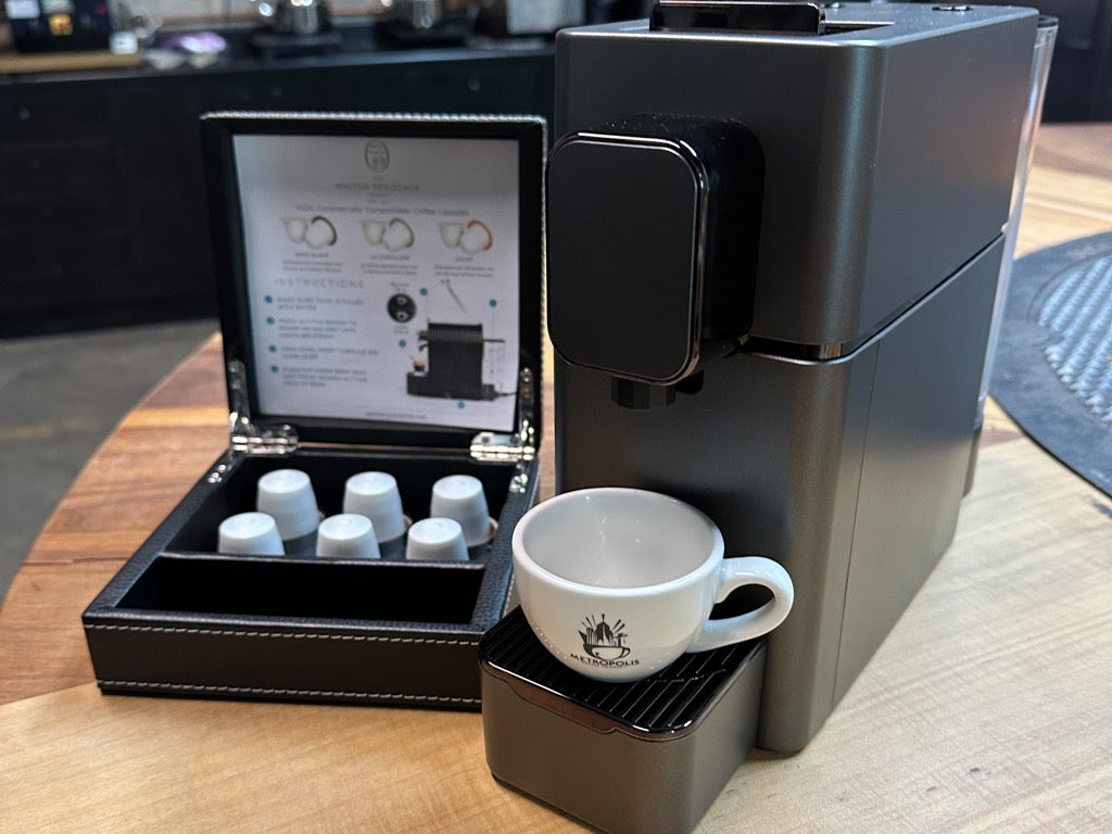 A Metropolis coffee capsule brewer alongside a display case.