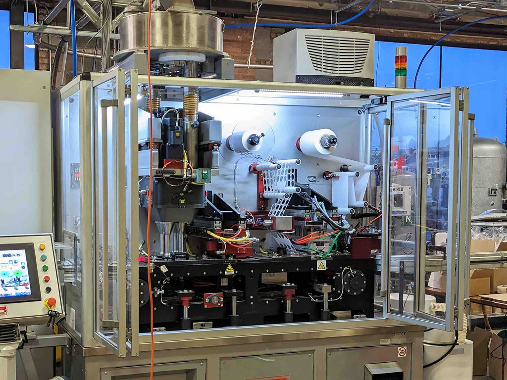 Coffee capsule filling machine in a factory.
