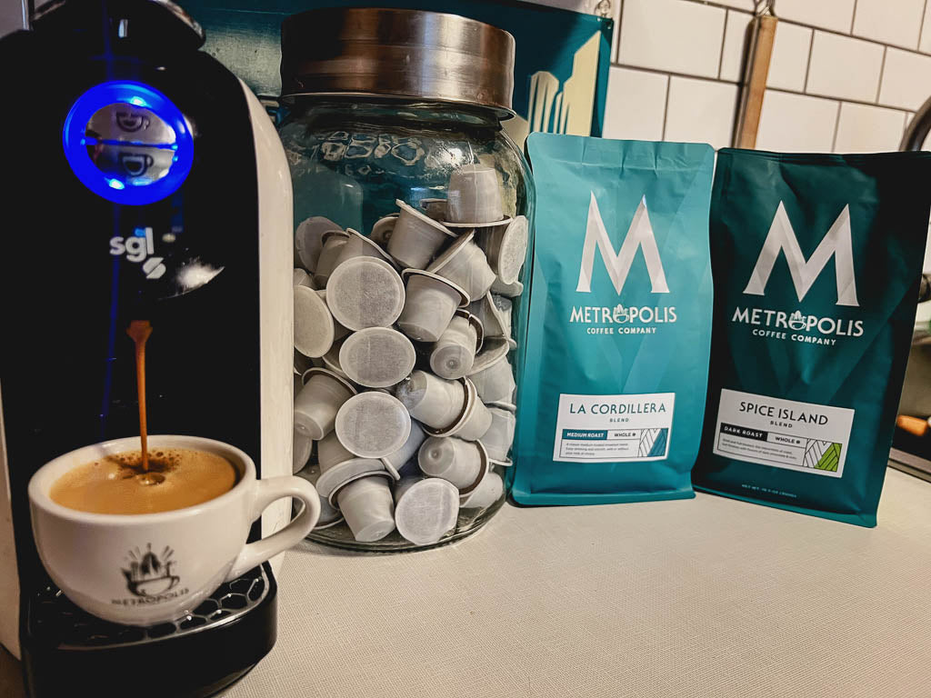 A selection of Metropolis Coffee pods with a coffee capsule brewer.