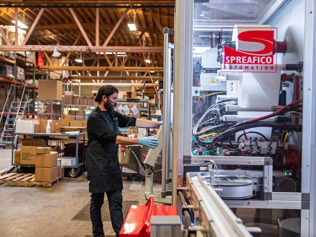 A factory worker manufactures private label coffee capsules.