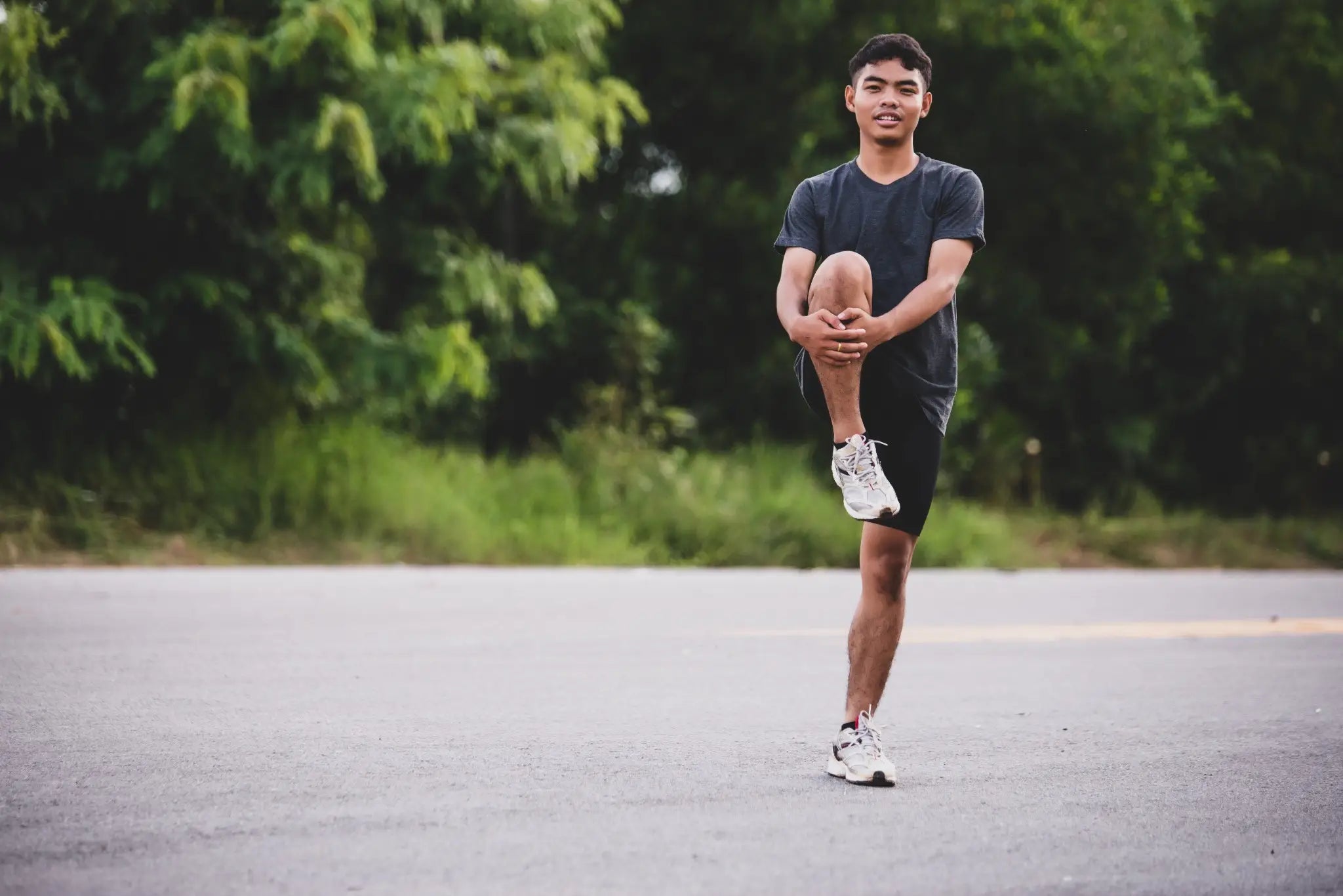 Male runner performing a stretching exercise as part of his post half-marathon recovery. Incorporate active recovery to maintain mobility.
