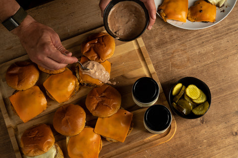 Topping Smash Burgers with Burger Sauce and Preparing to eat them