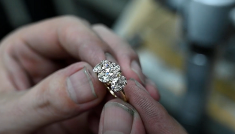 Jesse the Jeweler holding three stone engagement ring