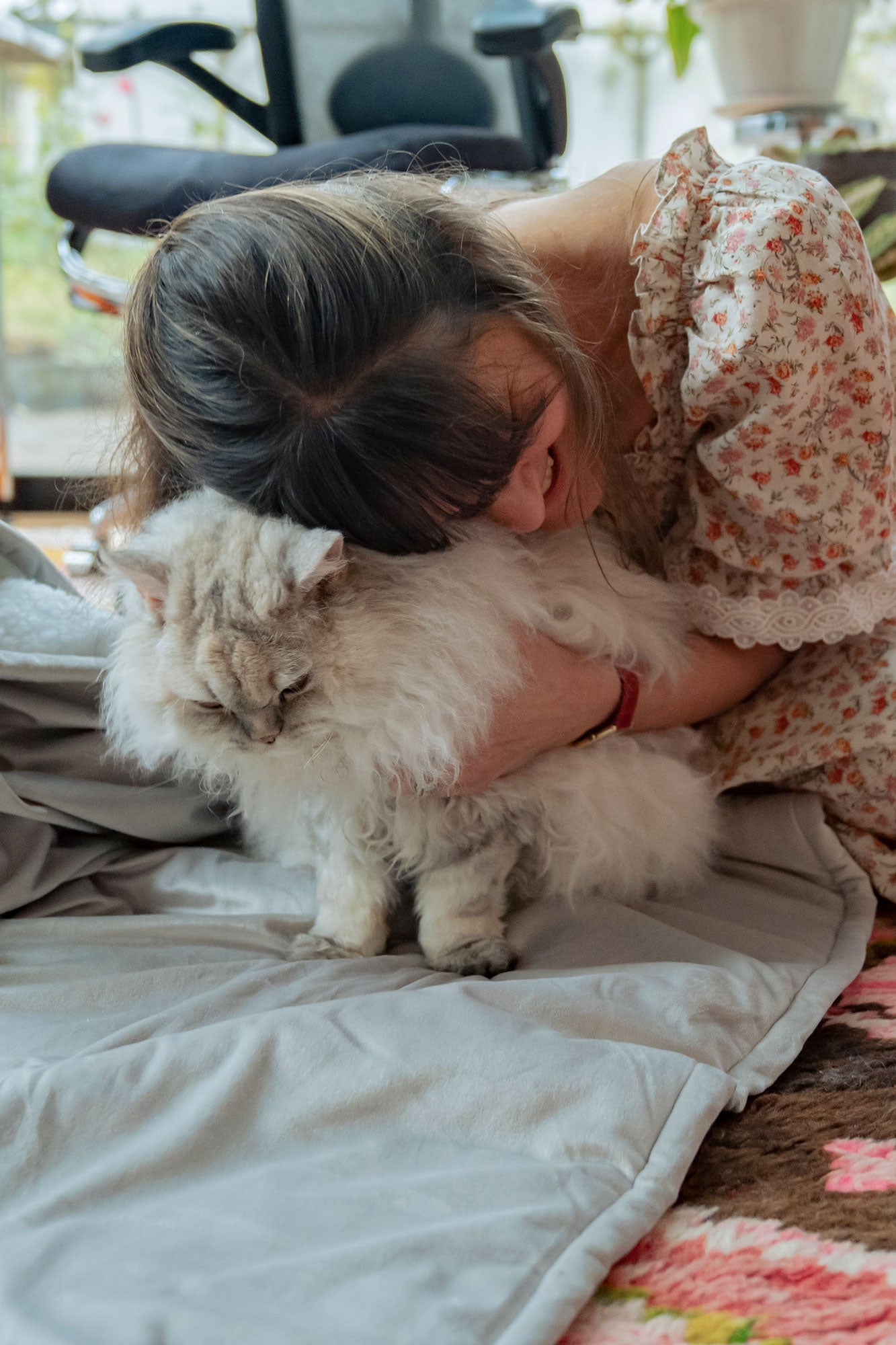 Woman embracing her Selkirk Rex