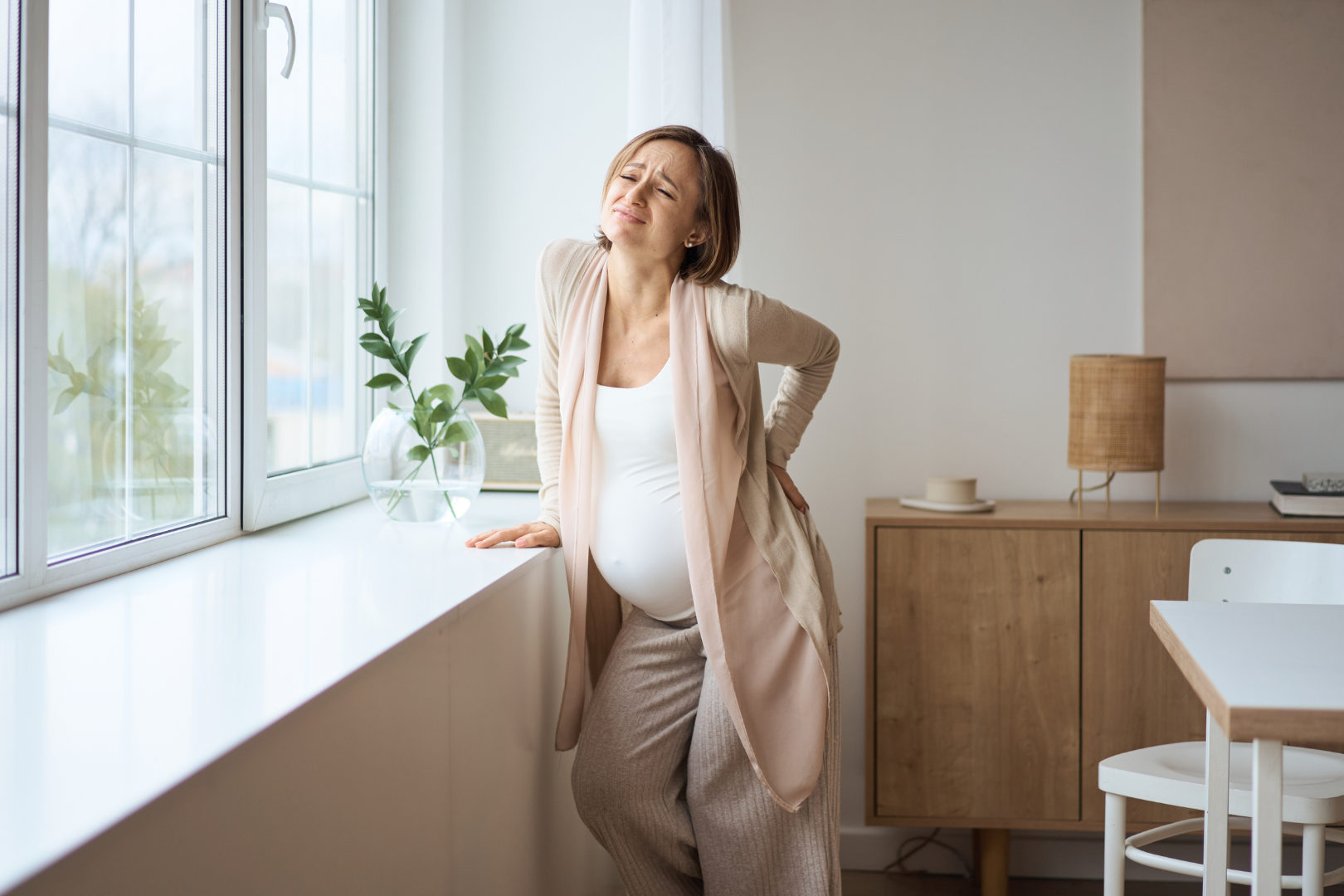 A woman holding her lower back in pain