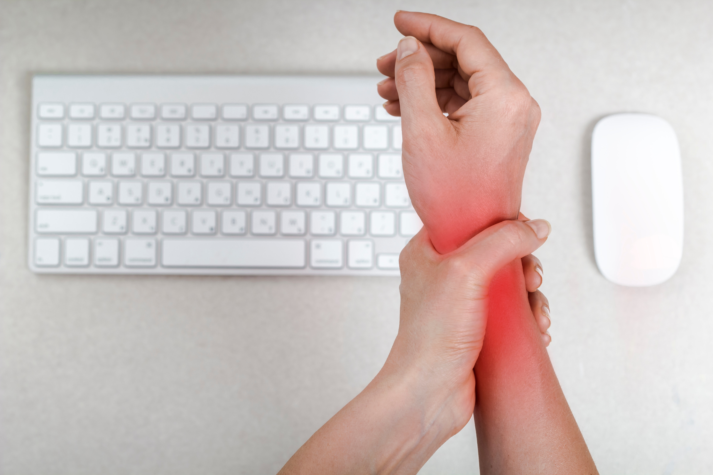 An image representative of carpal tunnel syndrome or someone holding their neck in pain at the computer.