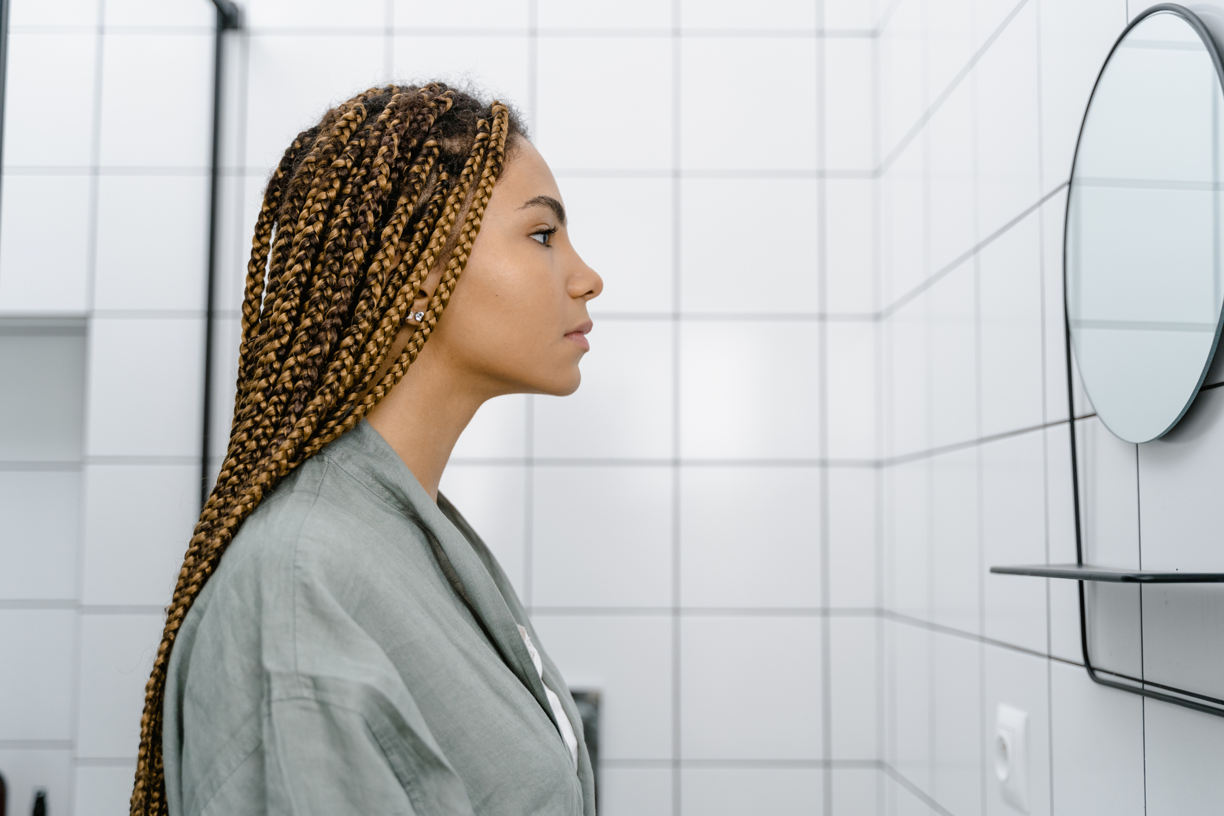 A PERSON ASSESSING THEIR POSTURE IN FRONT OF A MIRROR