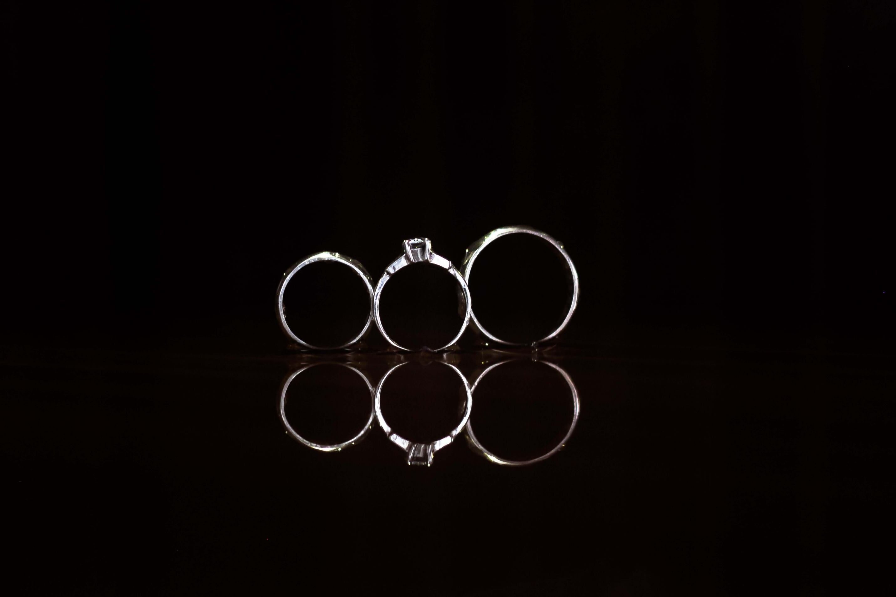 a row of silver rings standing up against a black background