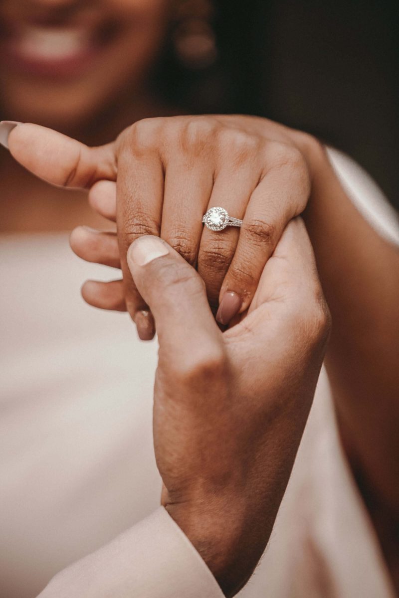 a couple holding hands with the women wearing an engagement ring