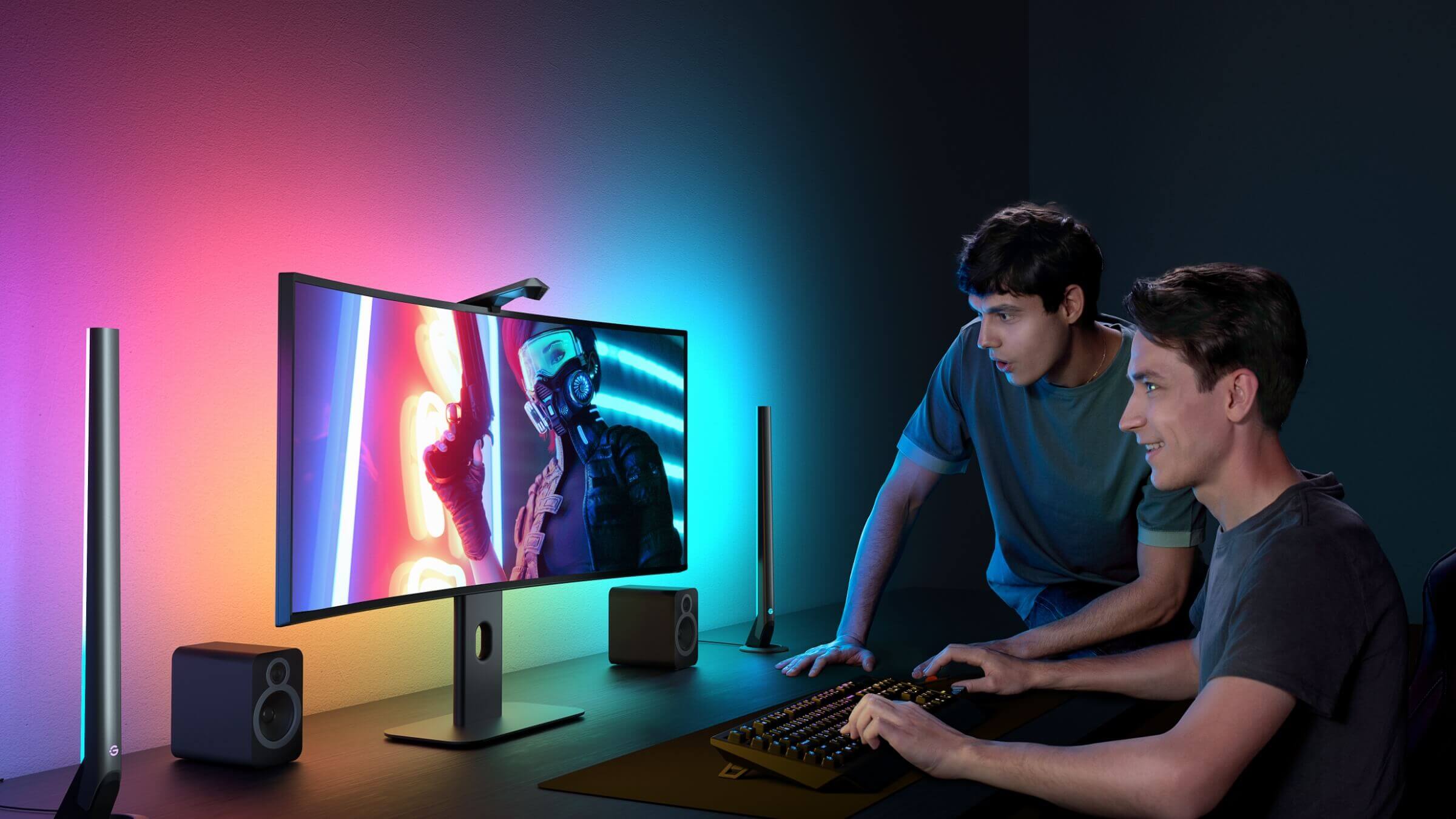 a couple of men sitting at a desk looking at a computer screen