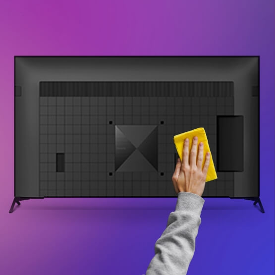 a hand holding a yellow paper in front of a computer screen