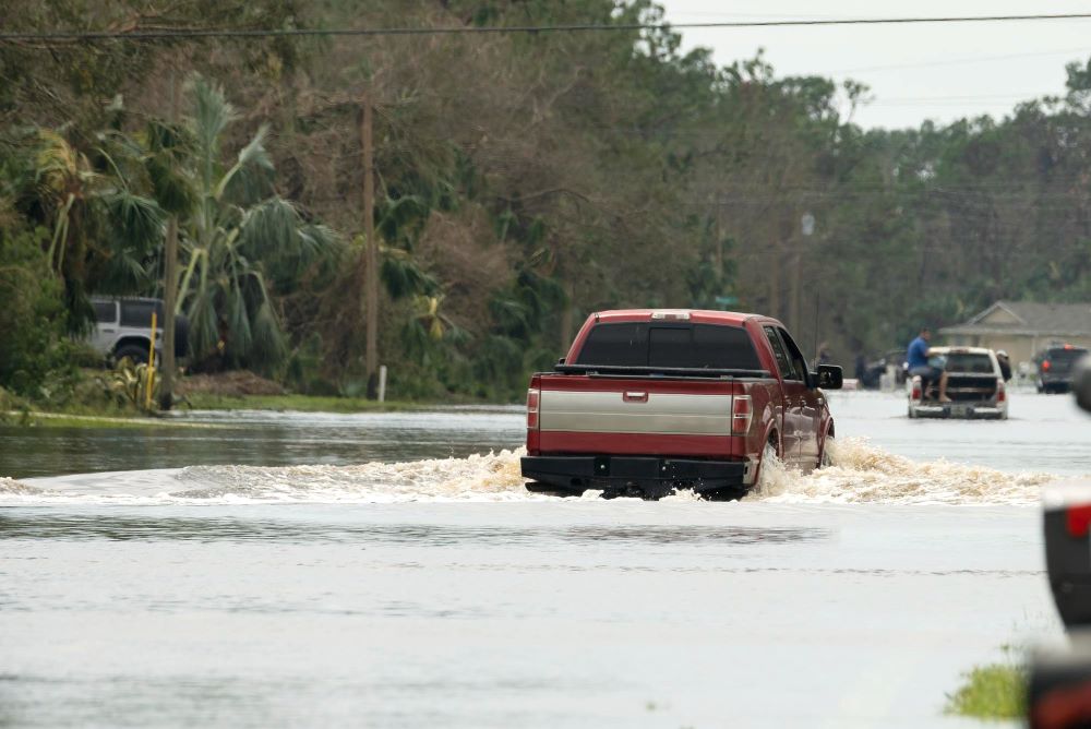 Cars drive through flooded streets in a Florida neighborhood after torrential rains from a hurricane.