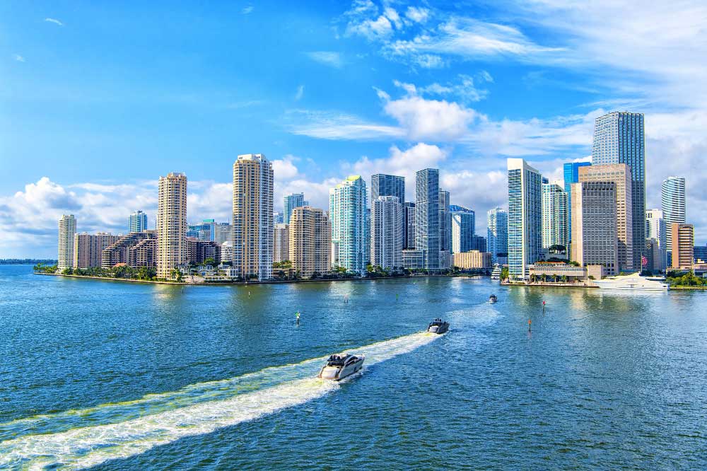 View of the Miami cityscape with motorboats passing downtown Miami on the waters of Biscayne Bay