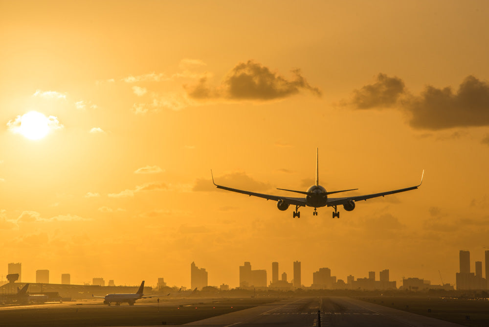 Airplane landing at Miami International Airport, with Miami Downtown skyline in background