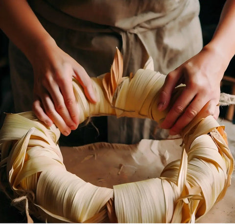 a person making a wreath out of corn husk