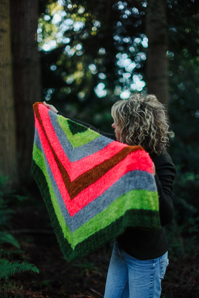 Sarah holding a triangular shawl out wide.