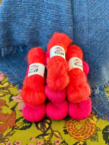 A pyramid of coral pink and red yarn.