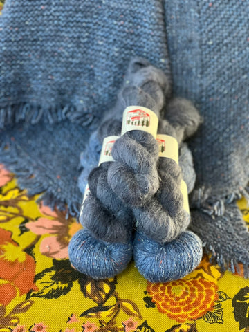 A pyramid of blue tweed and blue-gray yarn.