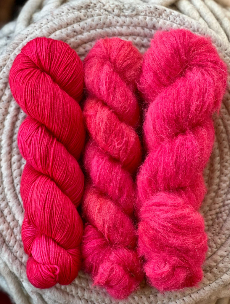 Three skeins of hot pink yarn.