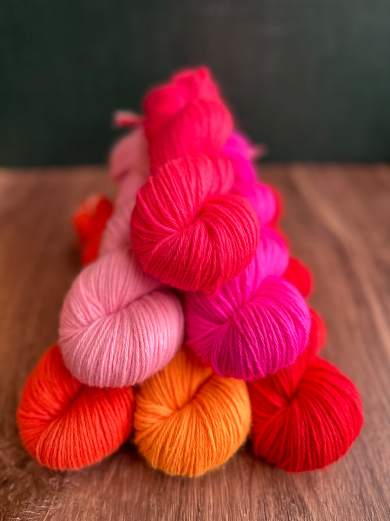 Pile of Dimond Laine Percy yarn in bright hand-dyed colors.