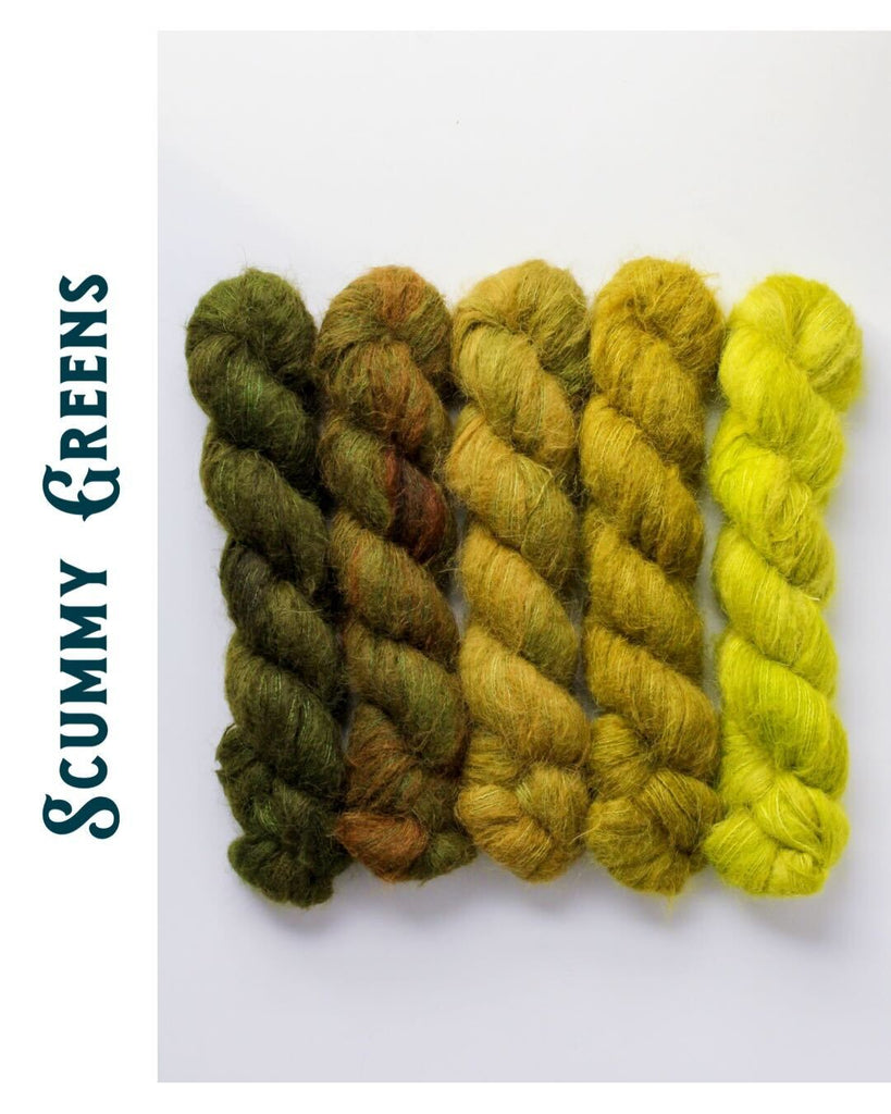 Five skeins of earthy green yarn lying flat on a white surface.