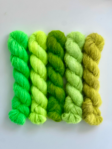 A line of five bright green skeins of yarn.