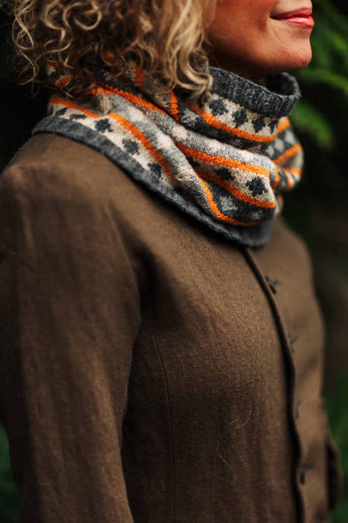 Sarah wearing a Diamond Cowl in shades of gray with an orange pop.
