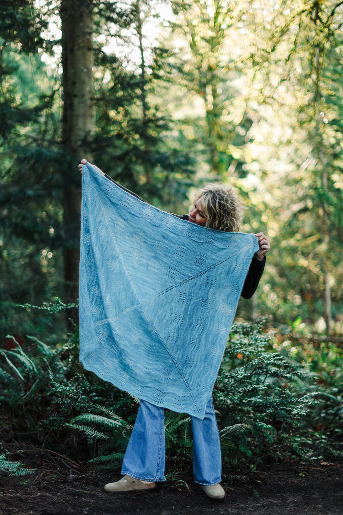 Sarah holding up a square shawl.