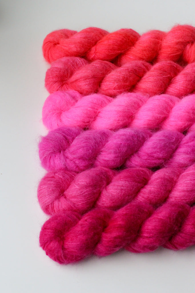 Six skeins of bright pink yarn.