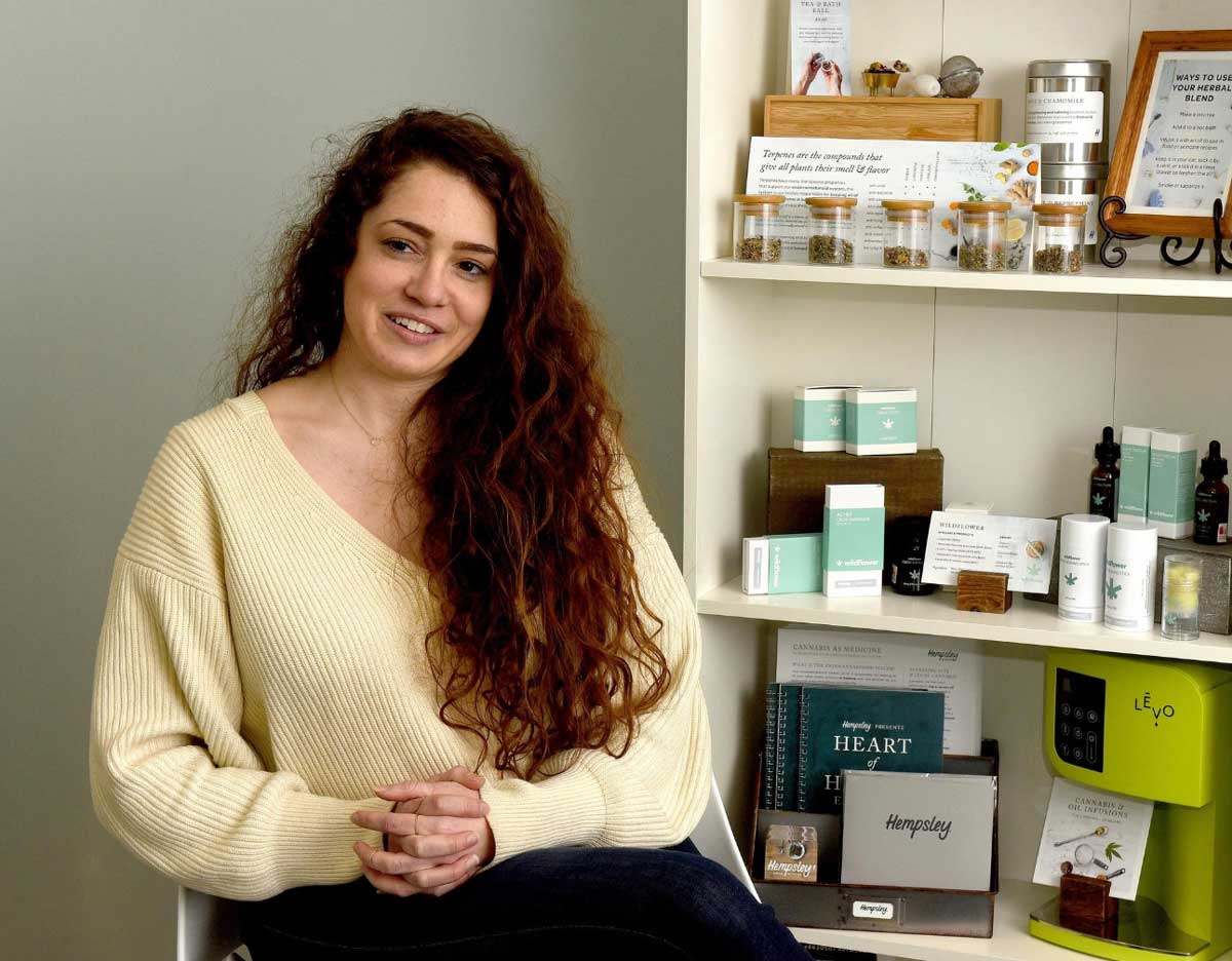 Kristen in Hempsley office next to shelf with CBD products and information