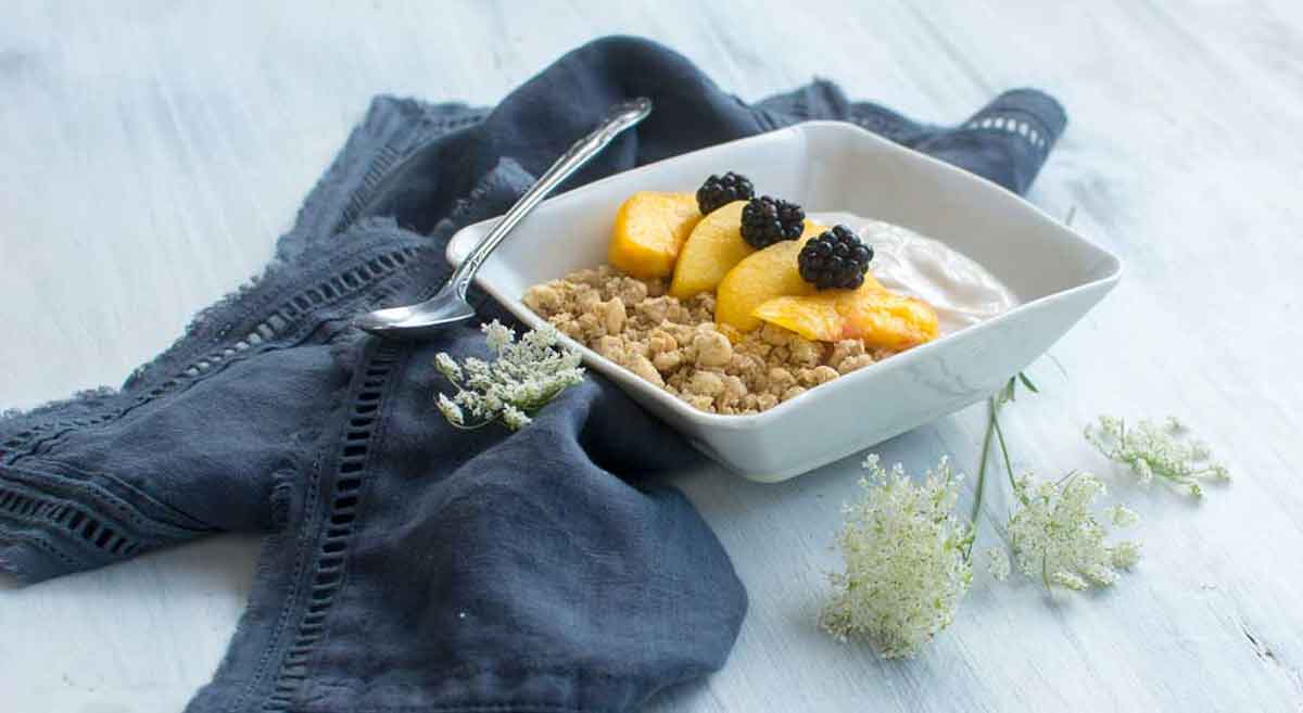 Simple CBD fruit dip with peaches, blackberries styled with vintage spoon and flowers