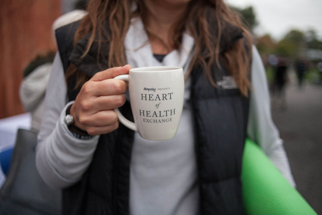 Woman holding Hempsley heart of health exchange mug with CBD coffee