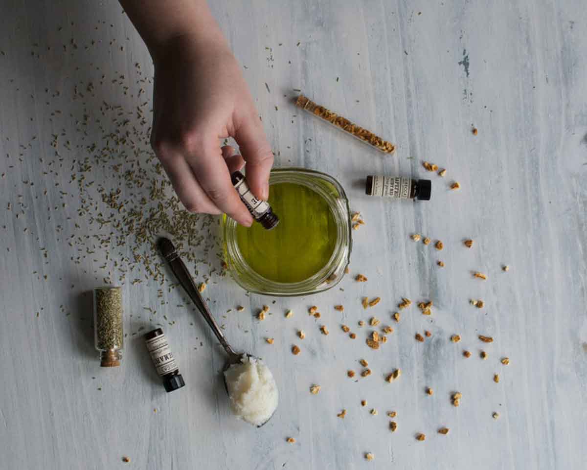 Woman adding essential oils to homemade hemp oil body butter