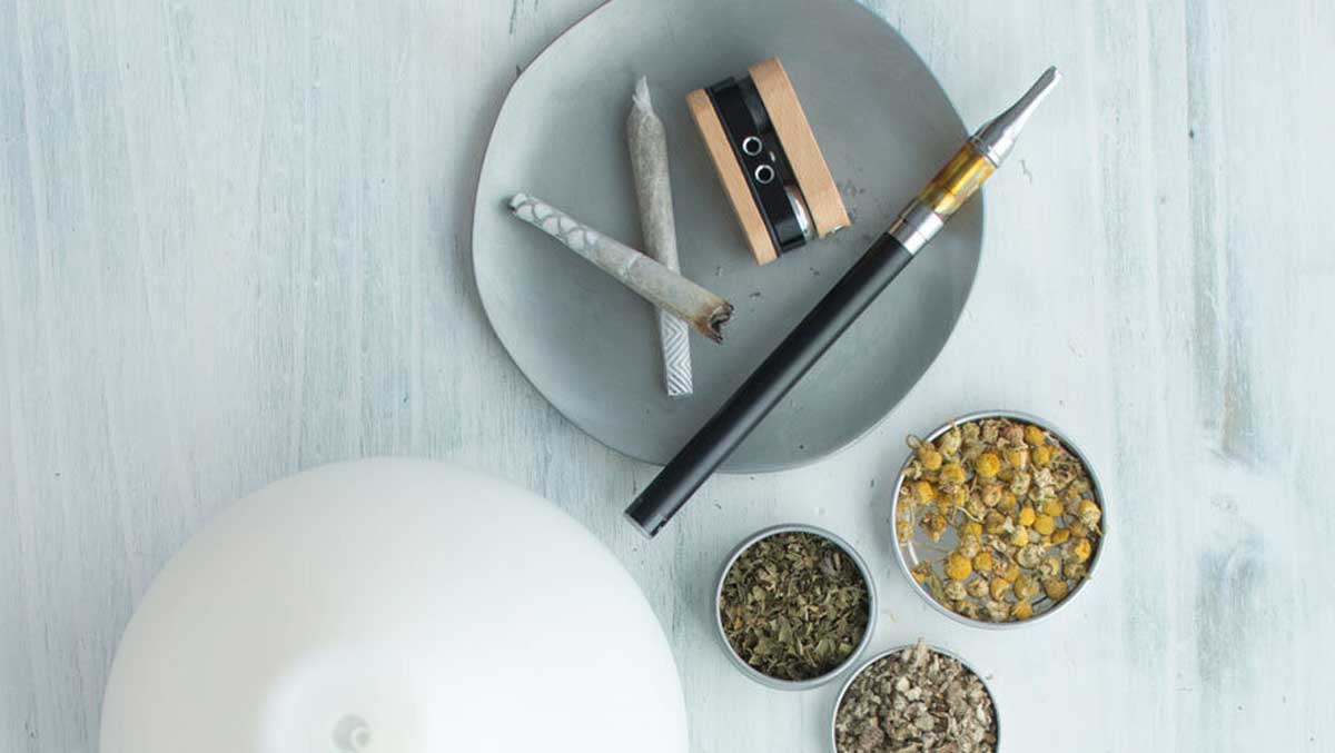 Dried herbs with the vaporization tools vape pen, pipe, joint, and essential oil diffuser