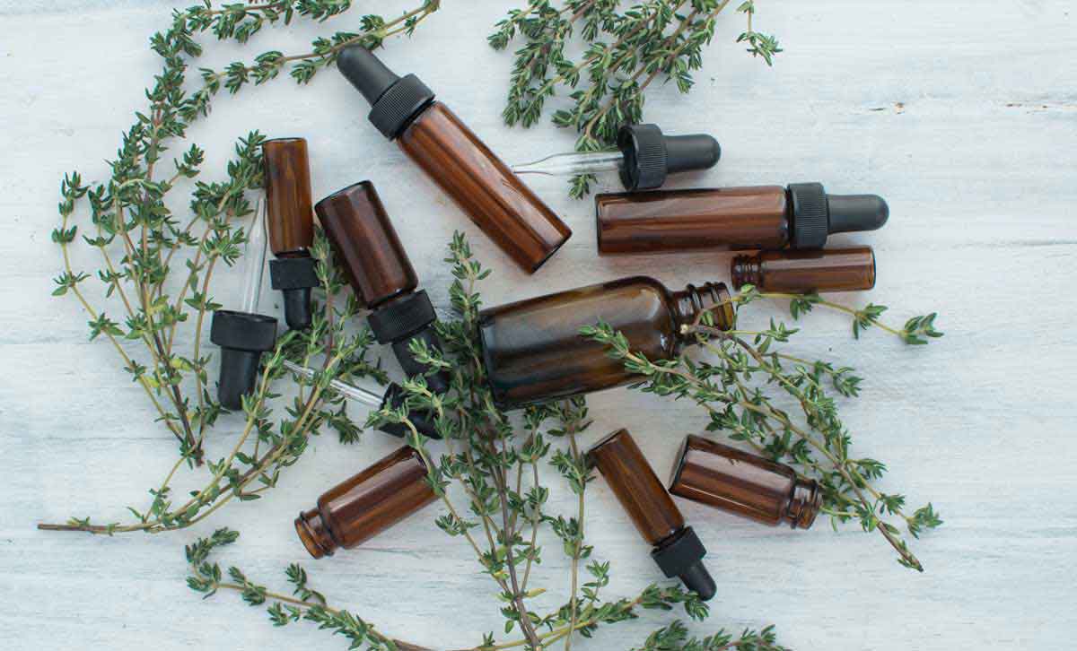 Tincture bottles with fresh thyme for making your own tinctures at home