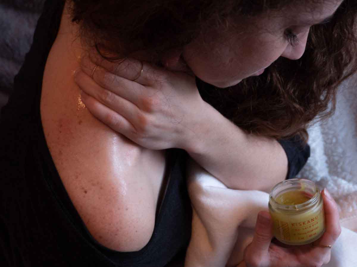 Woman massaging her neck with CBD balm