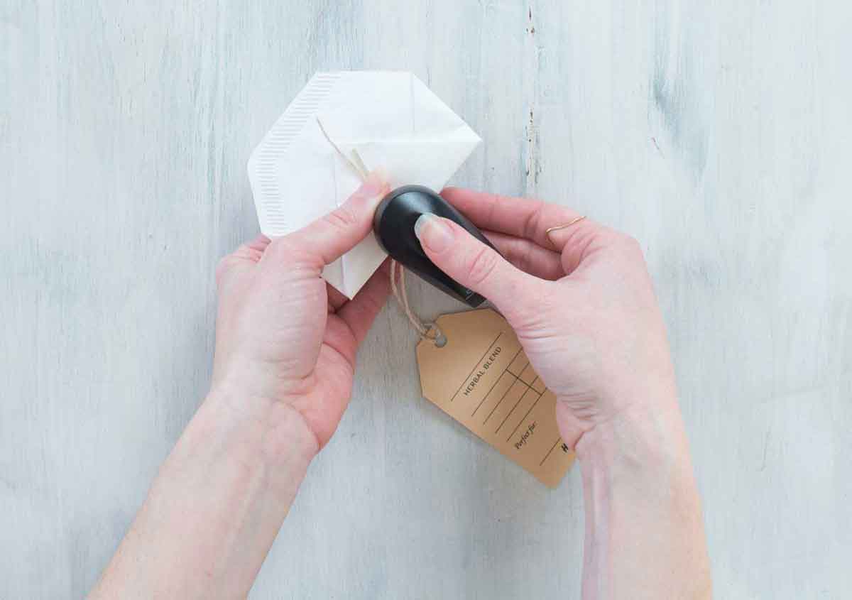 Woman stapling tag to homemade tea bag