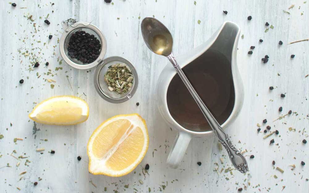 Elderberry and echinacea tea recipe with lemon and spoon with honey