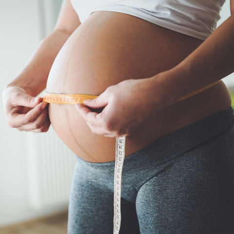 donna incinta che misura la sua pancia