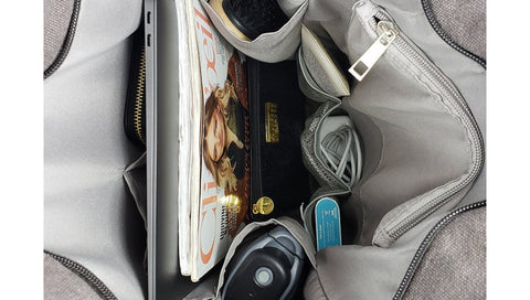 Magazines, gadgets, and personal items inside a bag - travel bag