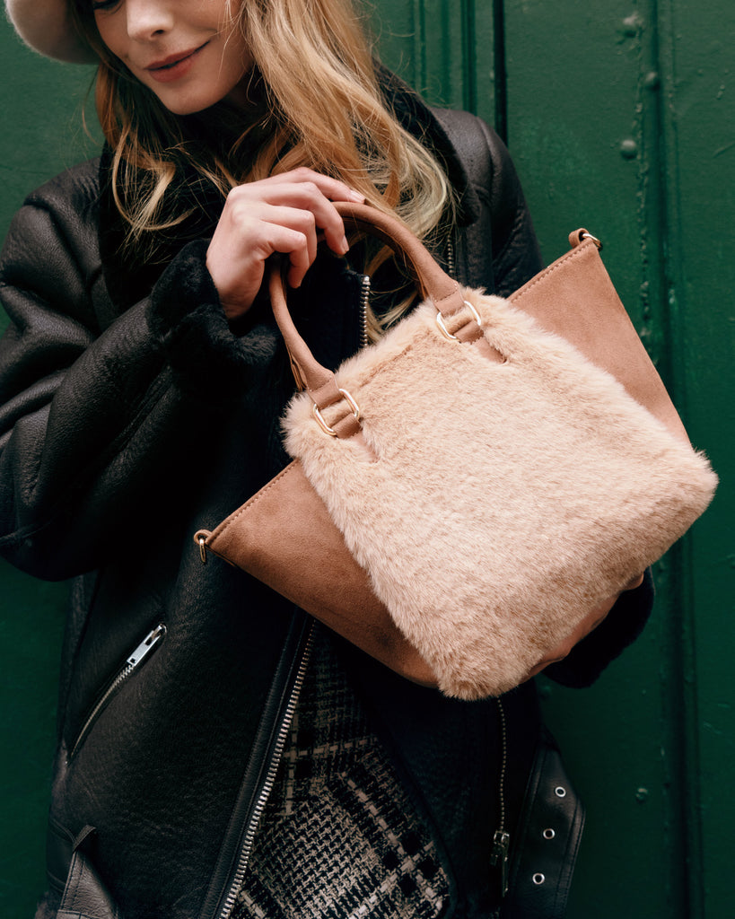 Look féminin avec un sac trapèze Vanessa Wu en suédine camel et fausse fourrure et une veste noire pour plus d'élégance