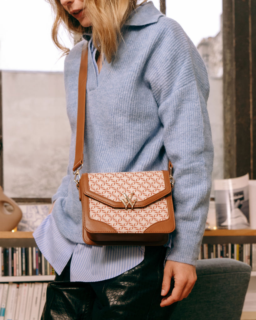 It-bag Vanessa Wu format cartable en couleur camel imprimé d'un monogramme blanc cassé avec un pull en maille bleu ciel