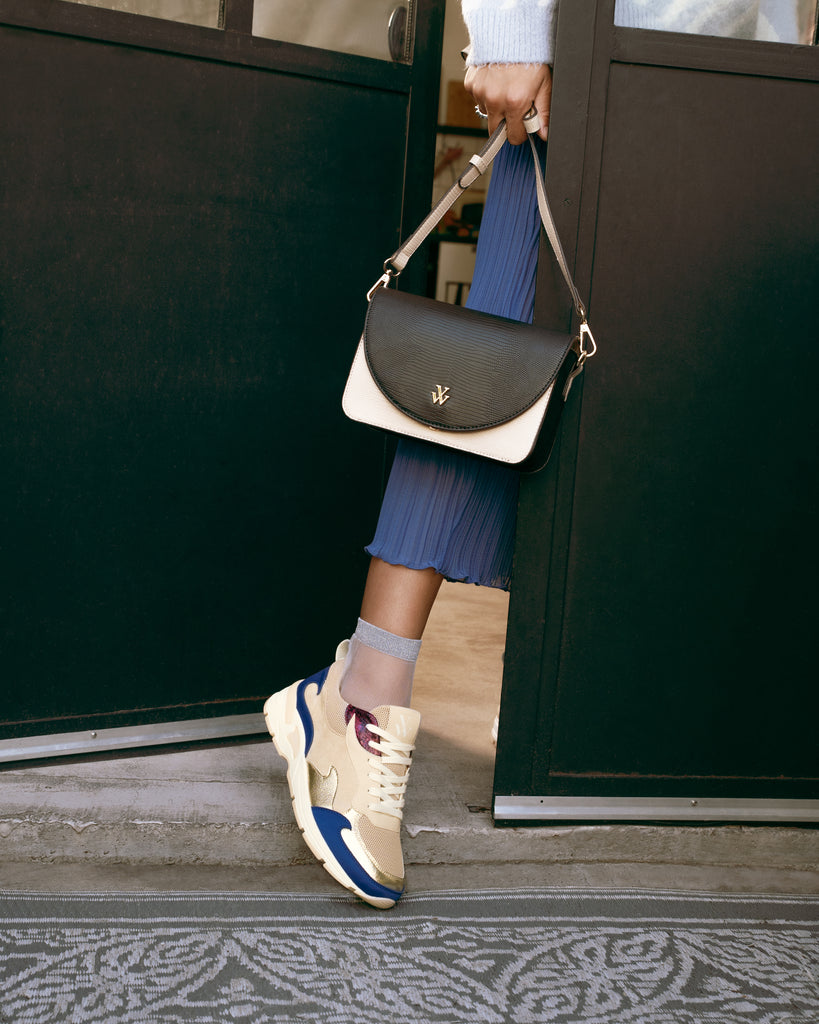 Baskets en mesh beige et découpes en forme de flammes bleu klein avec un petit sac bandoulière noir et blanc