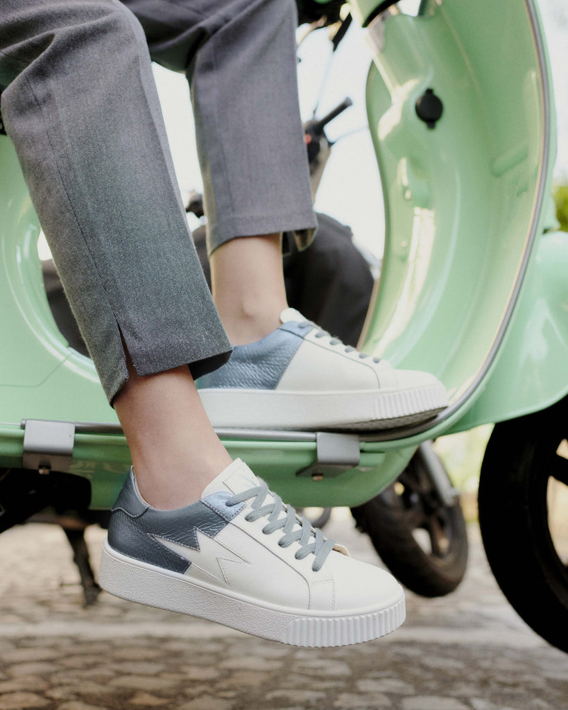 Balade en Vespa avec des baskets éclair Vanessa Wu blanches et découpe bleu pétrole effet serpent