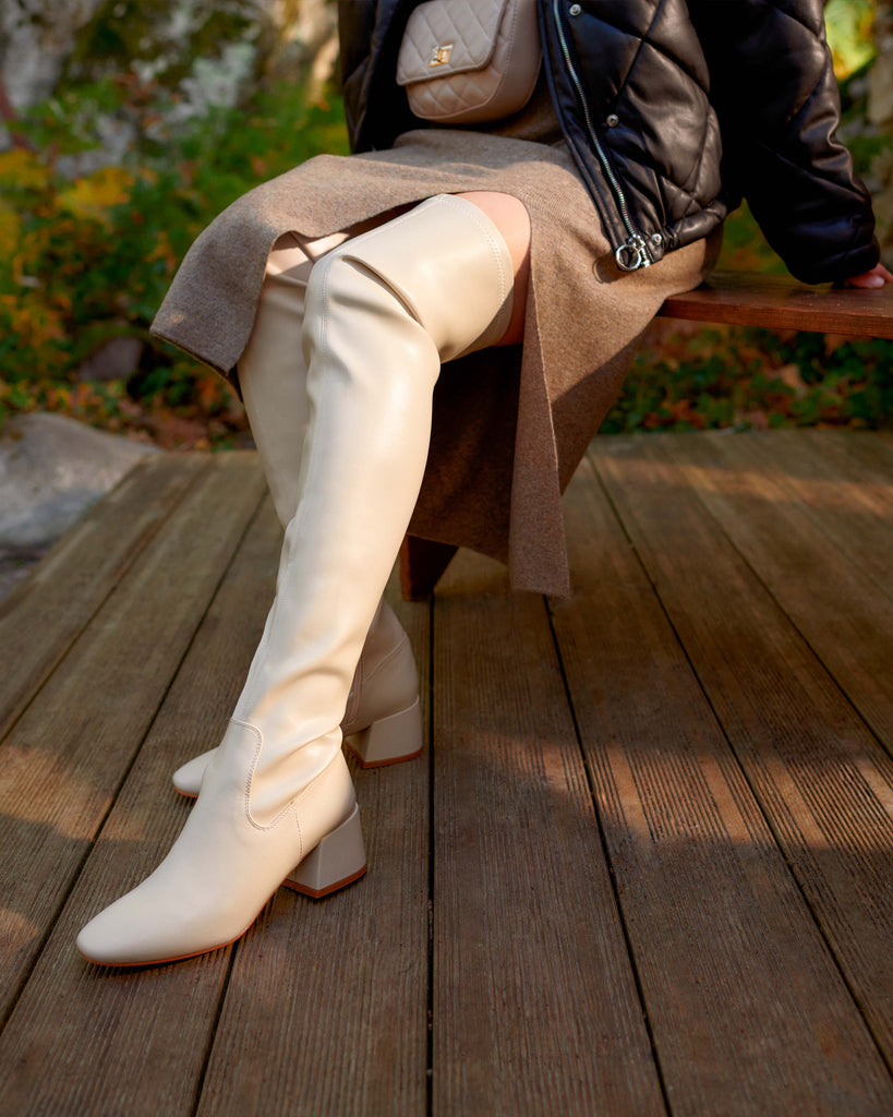 Tenue au style nordique pour une balade en forêt avec des cuissardes hautes beige clair et jupe mi-longue