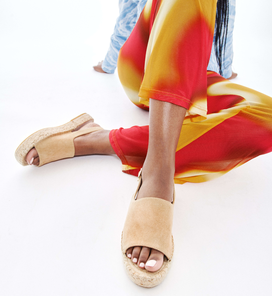 Young woman wearing colorful flowing pants and Marjolaine sandals with espadrille soles.