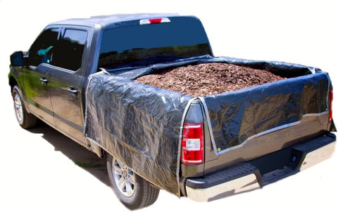 A pick up truck bed filled with mulch, protected by a tarp. They measured how much mulch fits in a truck bed before ordering the tarp.