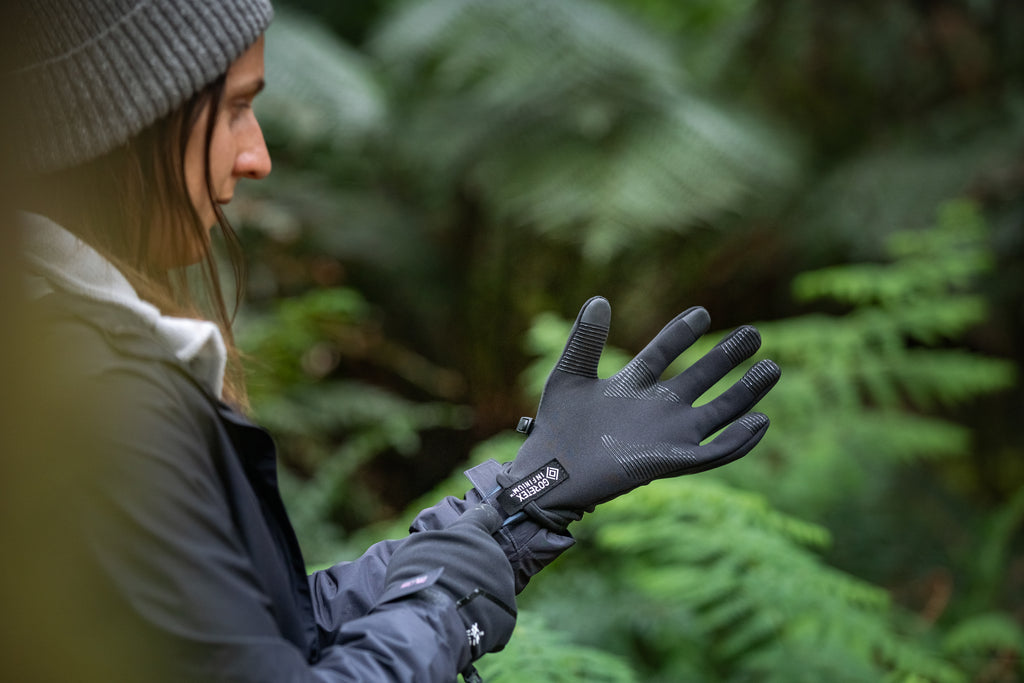 Women pulling up windproof gloves in the forest