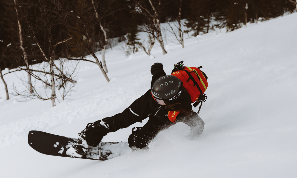 snowboarder in black making a turn